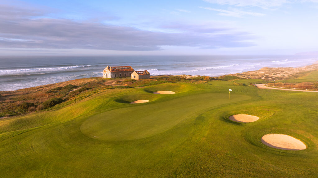 Green with white flag and bunkers and ocean view at Praia d'el Rey Golf Course