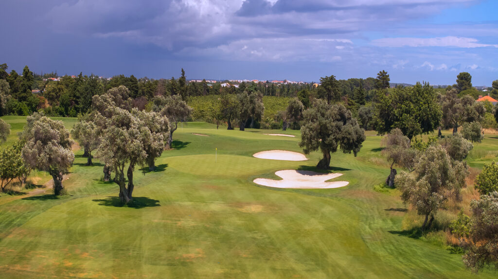 A green with bunkers next to it and trees around at Quinta De Cima Golf Course