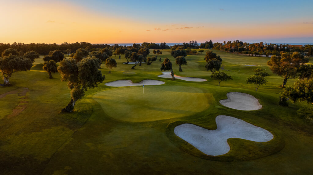 A green with bunkers and trees around at Quinta De Cima Golf Course