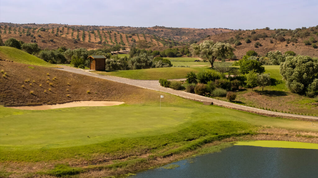 A green at Quinta do Vale Golf Course with hills in background