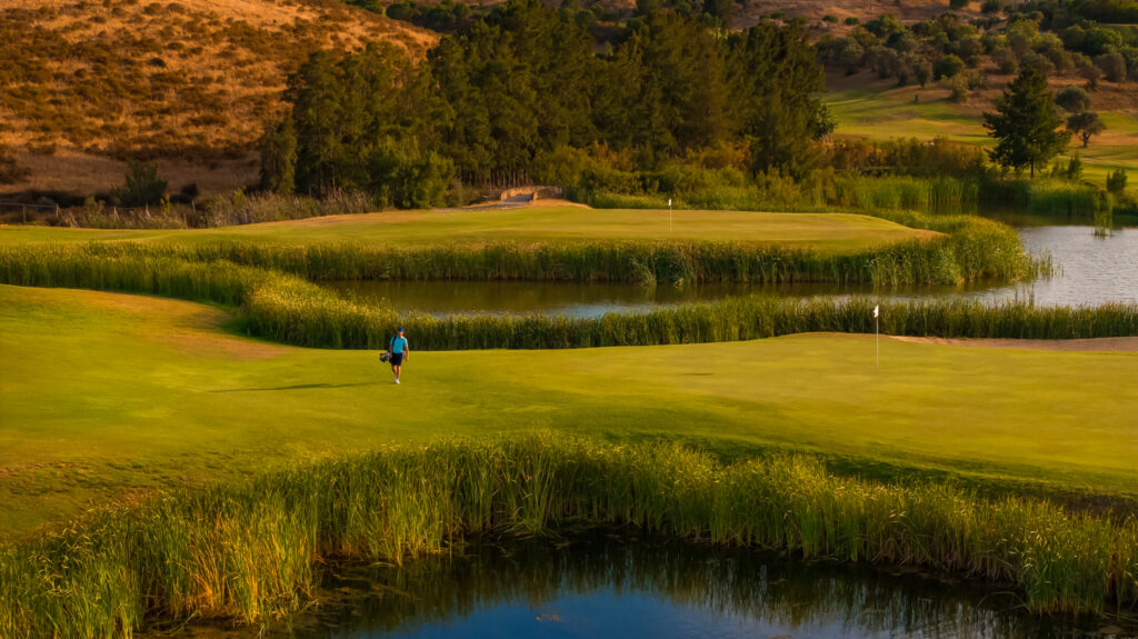 Man carrying clubs through Quinta do Vale Golf Course