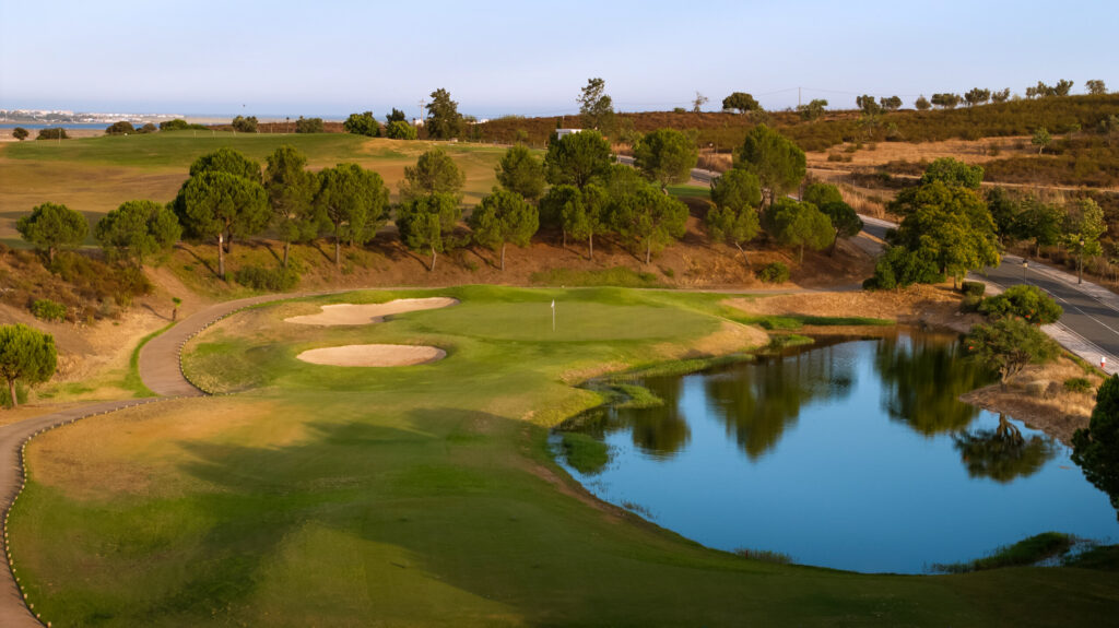 A green at Quinta do Vale Golf Course with a water hazard and two bunkers