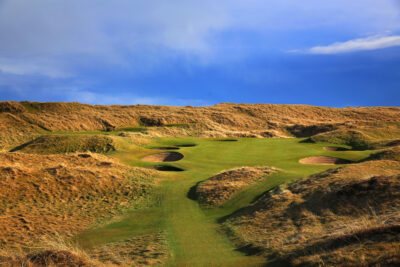 Hole with yellow flag at Balgownie Links at Royal Aberdeen Golf Club with bunkers around