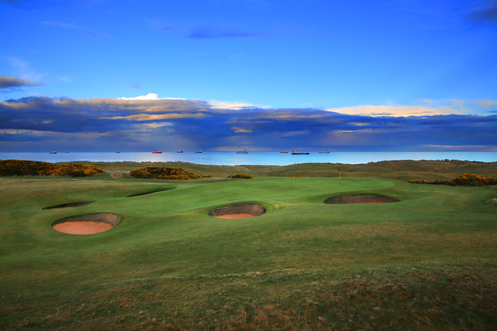 Hole with bunkers at Balgownie Links at Royal Aberdeen Golf Club with ocean in background