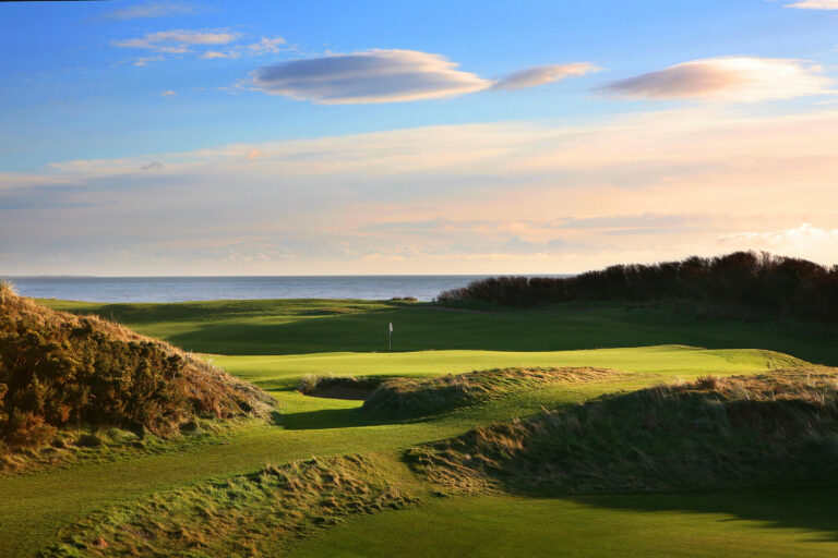 Hole at Annesley Links at Royal County Down with ocean in distance