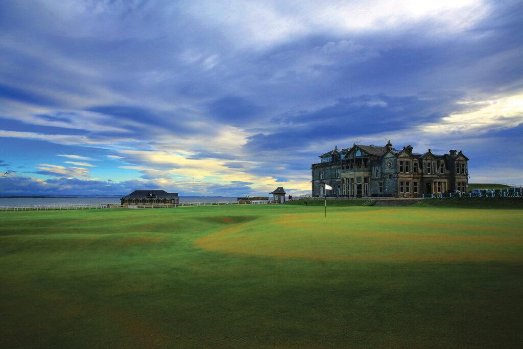 Hole with white flag at The Old Course at St Andrews with building in background