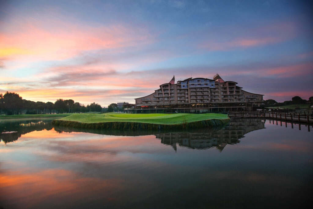 Lake with fairway and building in background at Sueno Golf Club - Dunes Course