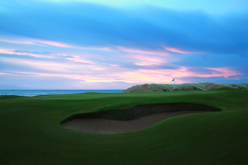 Hole with bunker at Trump International Golf Links with ocean in background