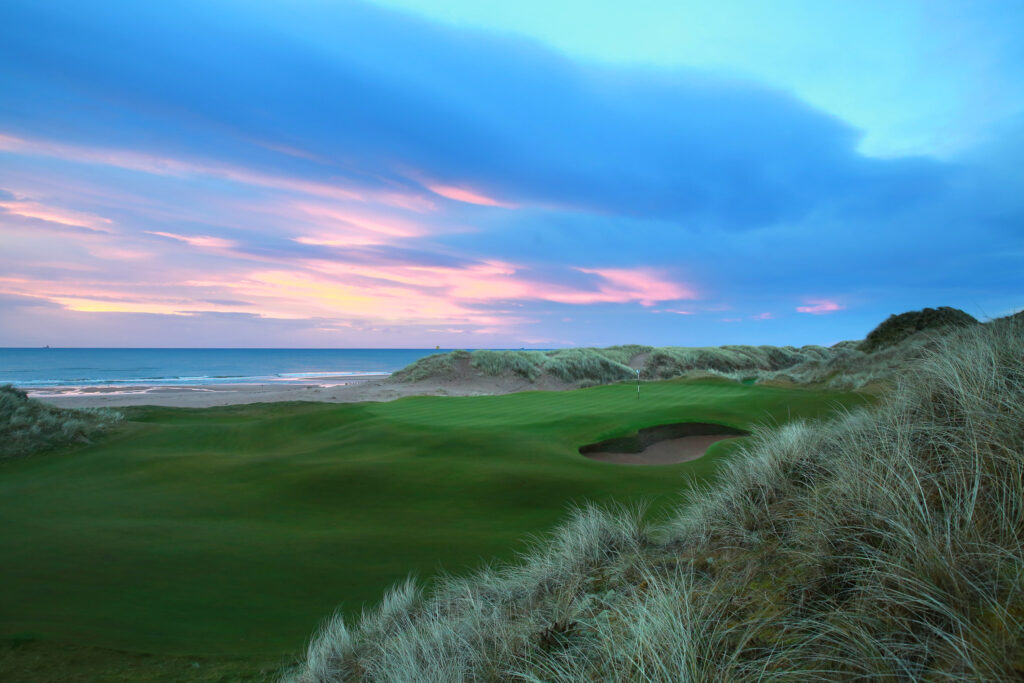 Hole with bunker atTrump International Golf Links with beach view at sunset