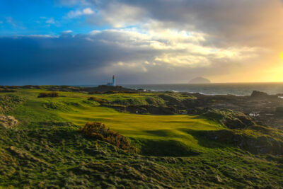 Hole with white flag at Trump Turnberry - Ailsa with lighthouse in background