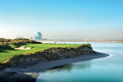 Hole with bunker next to it at Yas Links Golf Club next to the ocean