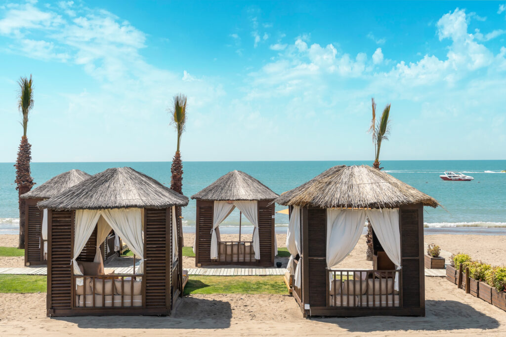 Loungers in huts on beach at Kaya Palazzo Golf Resort