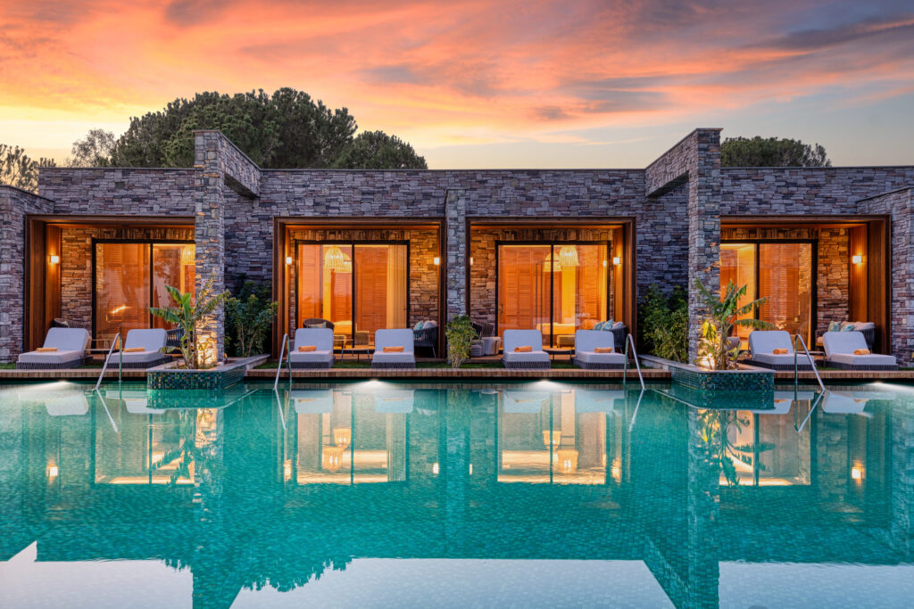 Small outdoor pool with villas at Kaya Palazzo Golf Resort at sunset