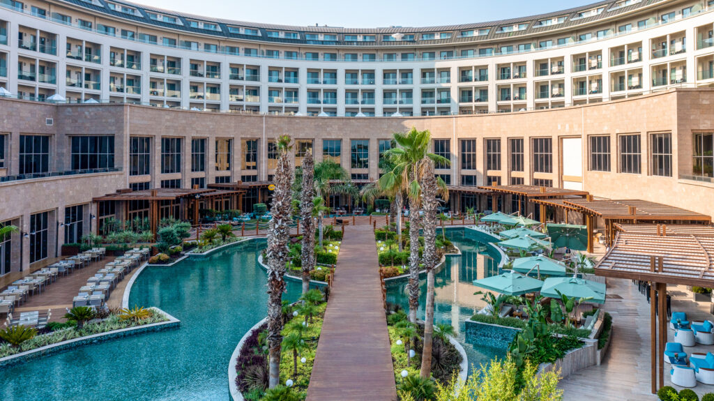 Outdoor pool with hotel surrounding at Kaya Palazzo Golf Resort