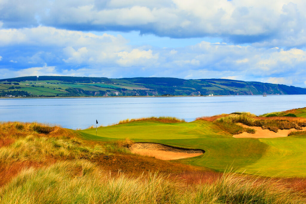 Hole with bunkers at Castle Stuart Golf Links with ocean view