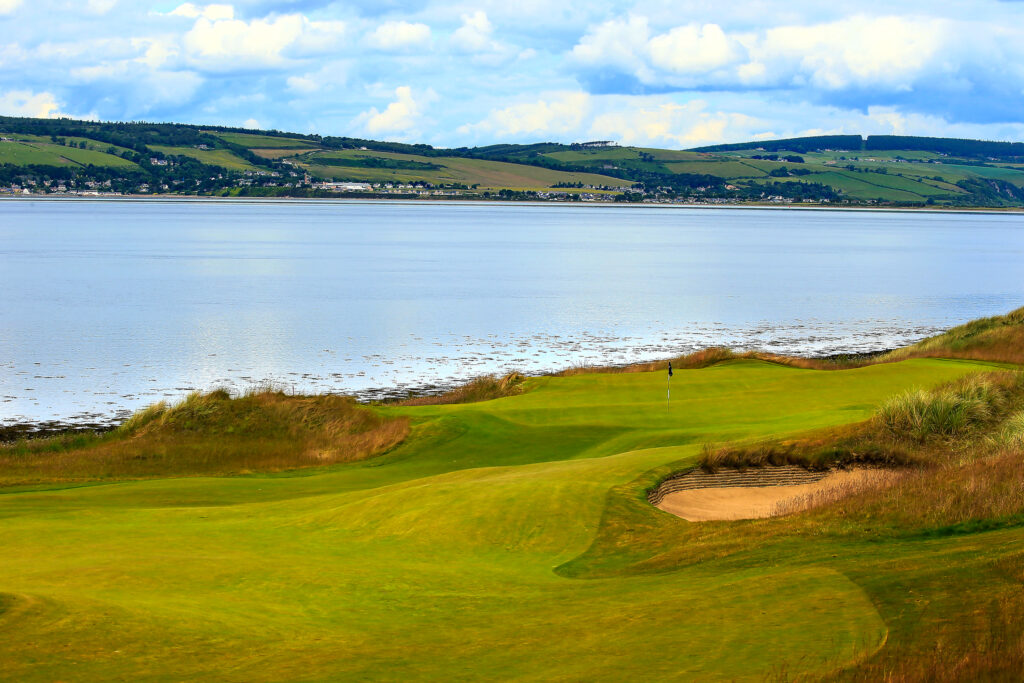 Hole with bunker at Castle Stuart Golf Links with ocean view