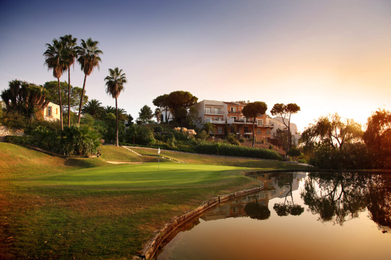 Hole with lake and trees around at sunset at La Quinta Golf Course