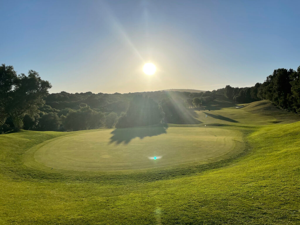 A hole with sun shining in background at La Canada Golf Course