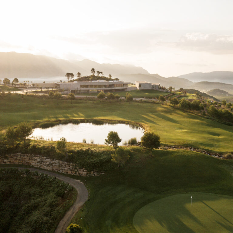 Lake on fairway with building in background at La Galiana Golf Course