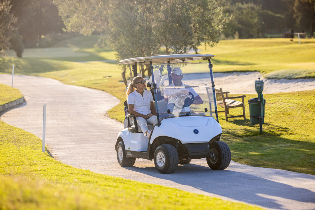 People driving buggy around La Sella Golf Course