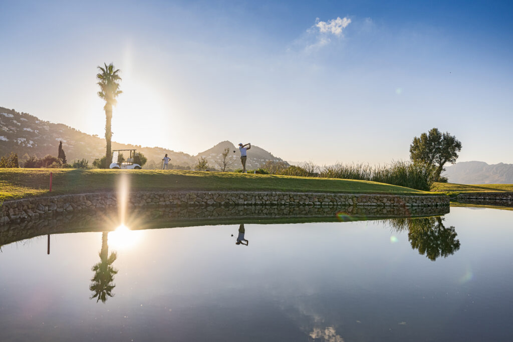 People playing golf at La Sella Golf Course next to a lake