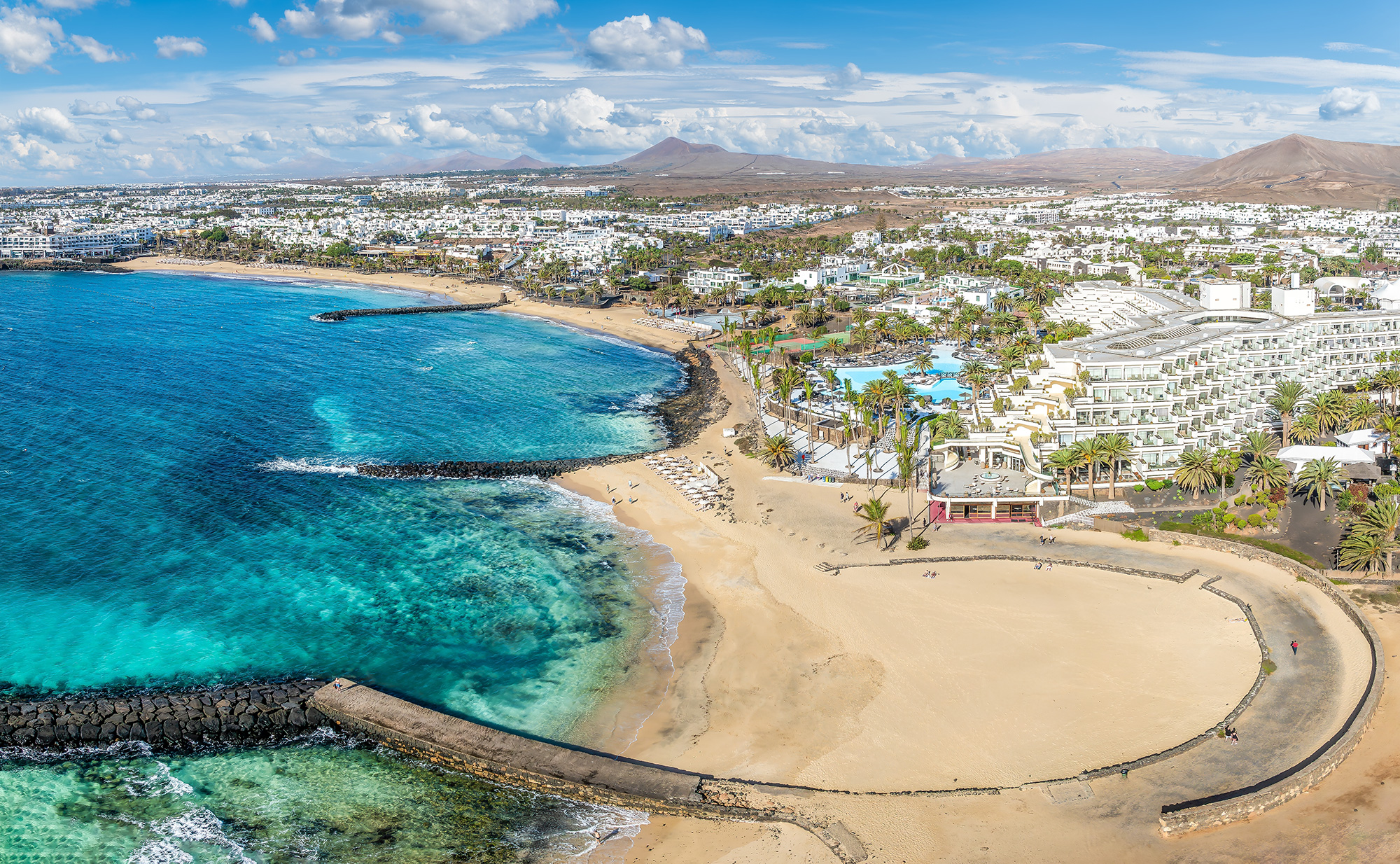 a picture of a town with a beach in lanzarote, canary islands
