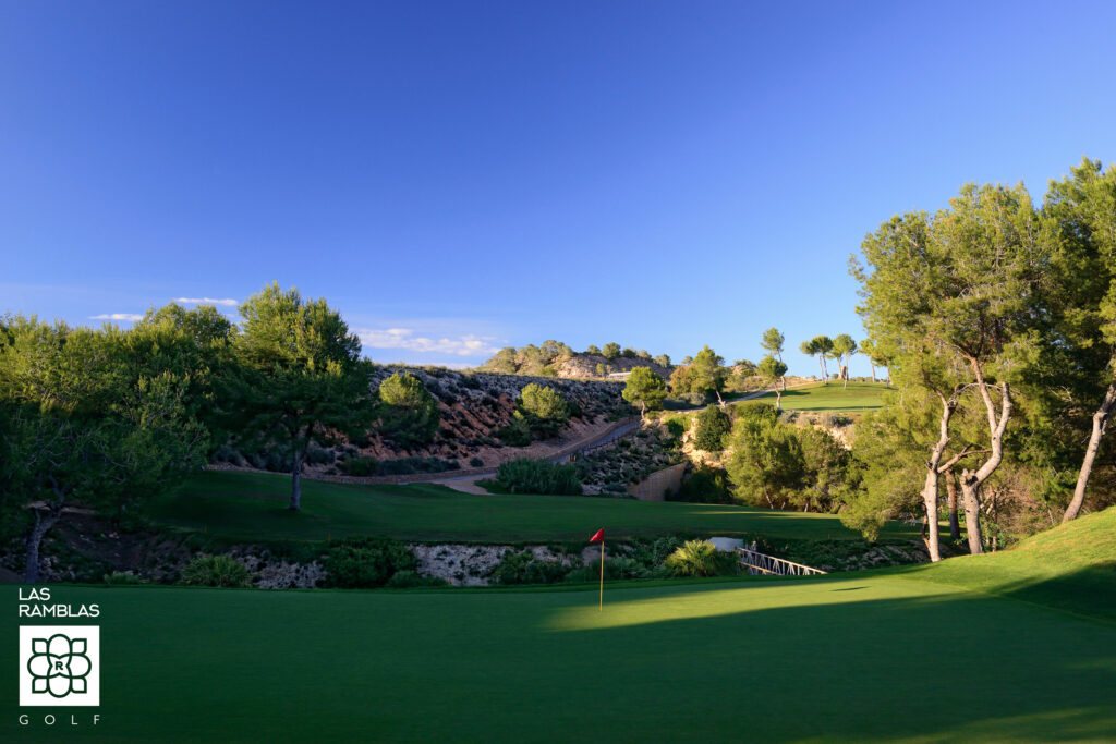 A hole with a red flag at Las Ramblas Golf Course