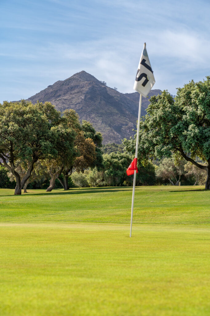 Hole at Lauro Golf Course with mountain and trees in background