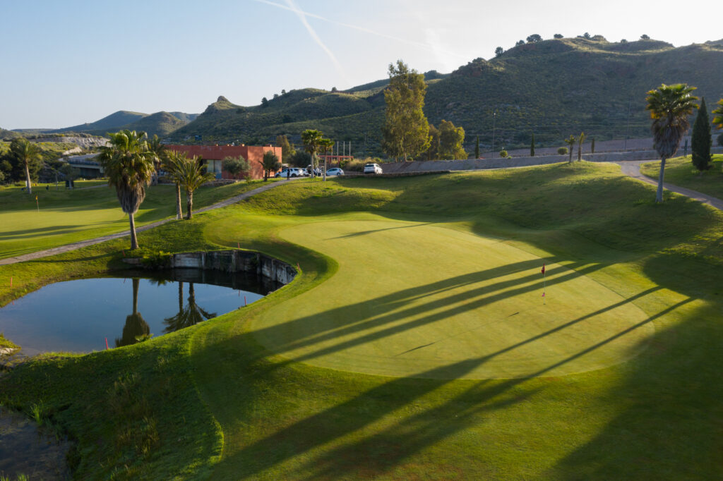 Hole with water hazard with hill in background at Lorca Golf Course