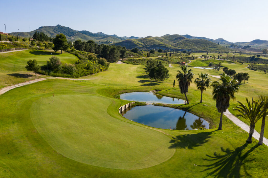 Hole with water hazards and hills in background at Lorca Golf Course