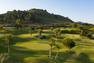 Hole with trees and hill in background at Lorca Golf Course