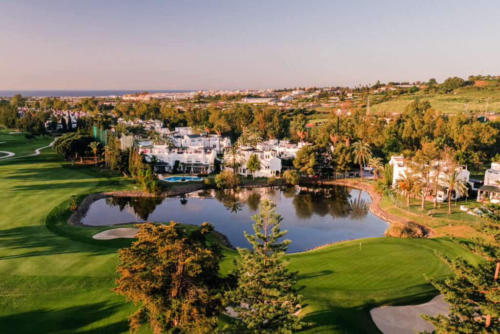 Aerial view of lake on fairway at Los Naranjos Golf Course with buildings in background