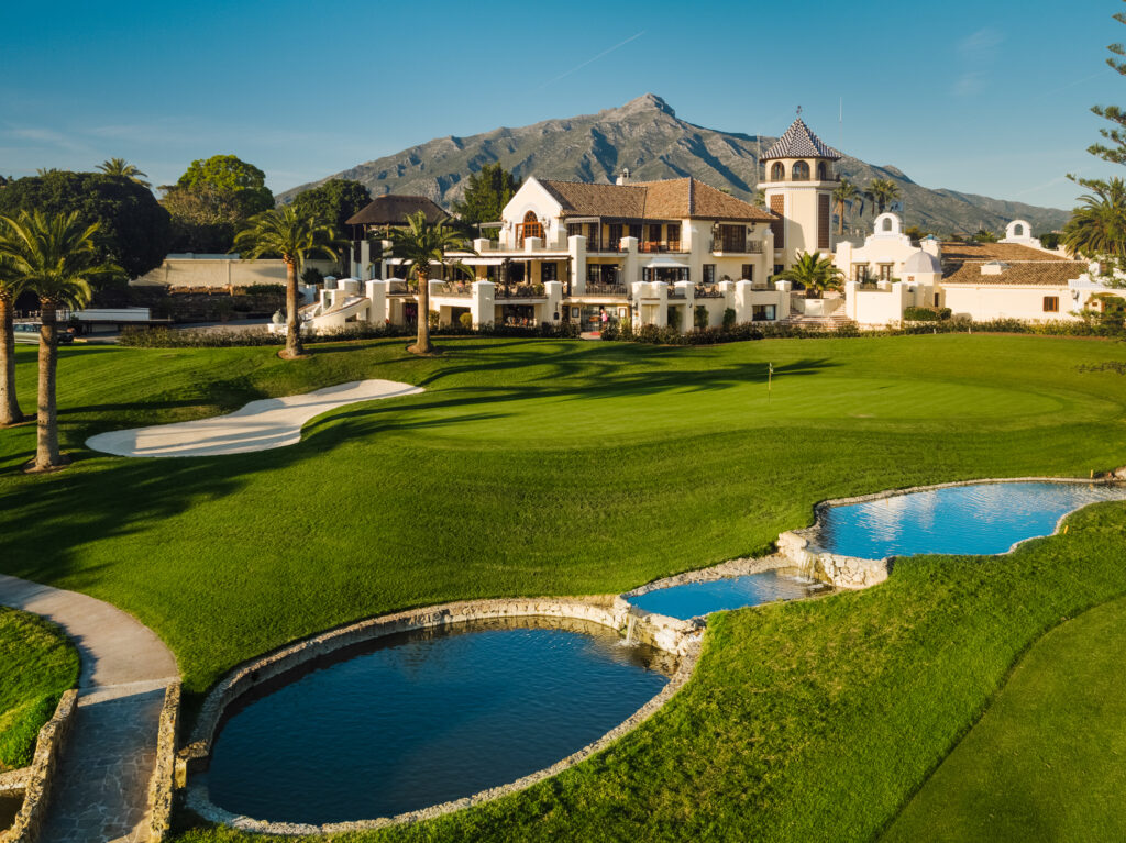 Hole with bunkers and water hazards with clubhouse in background at Los Naranjos Golf Course