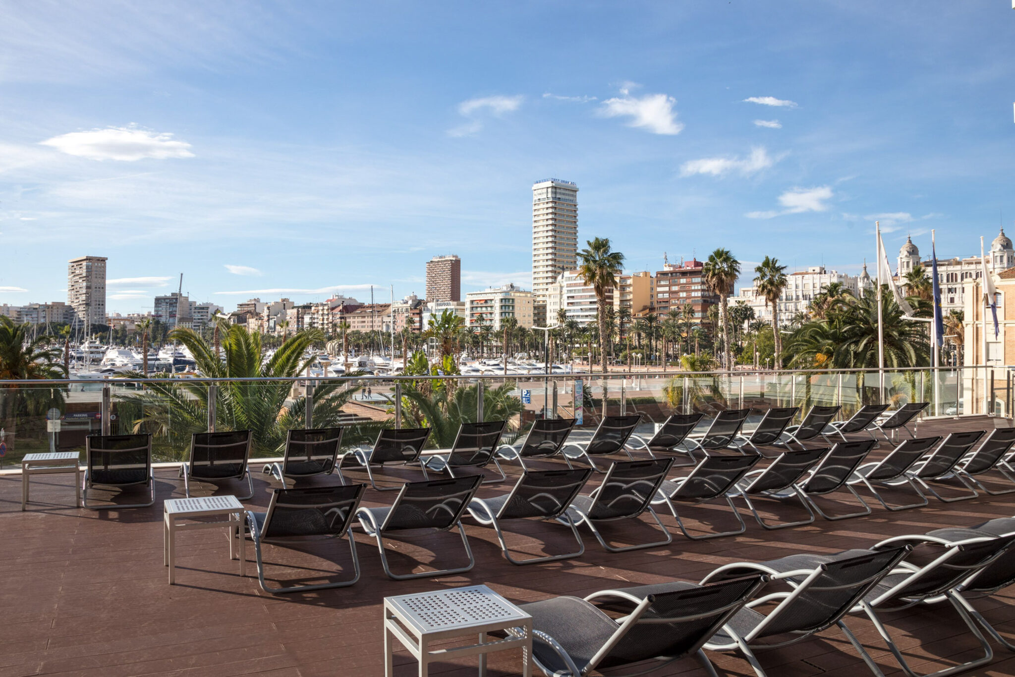 Outdoor seating area with view of the marina at Melia Alicante