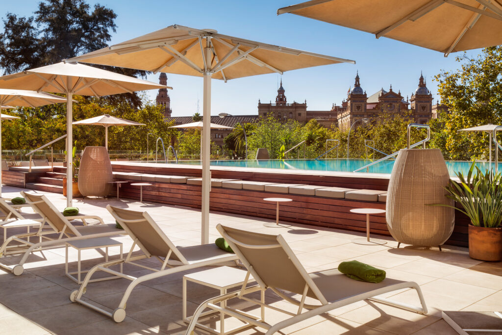 Outdoor pool with sun loungers at Melia Sevilla