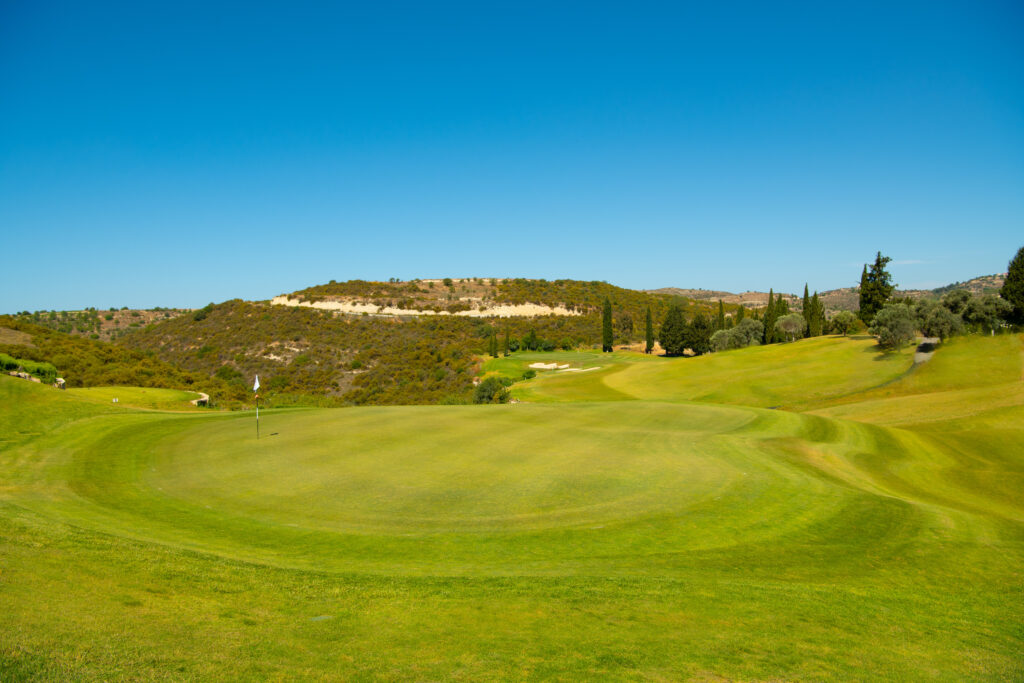 Hole with hills and trees in background at Minthis Golf Club