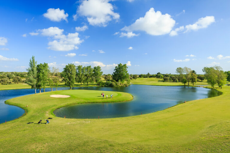 People playing golf at Montado Golf Course with a lake and trees