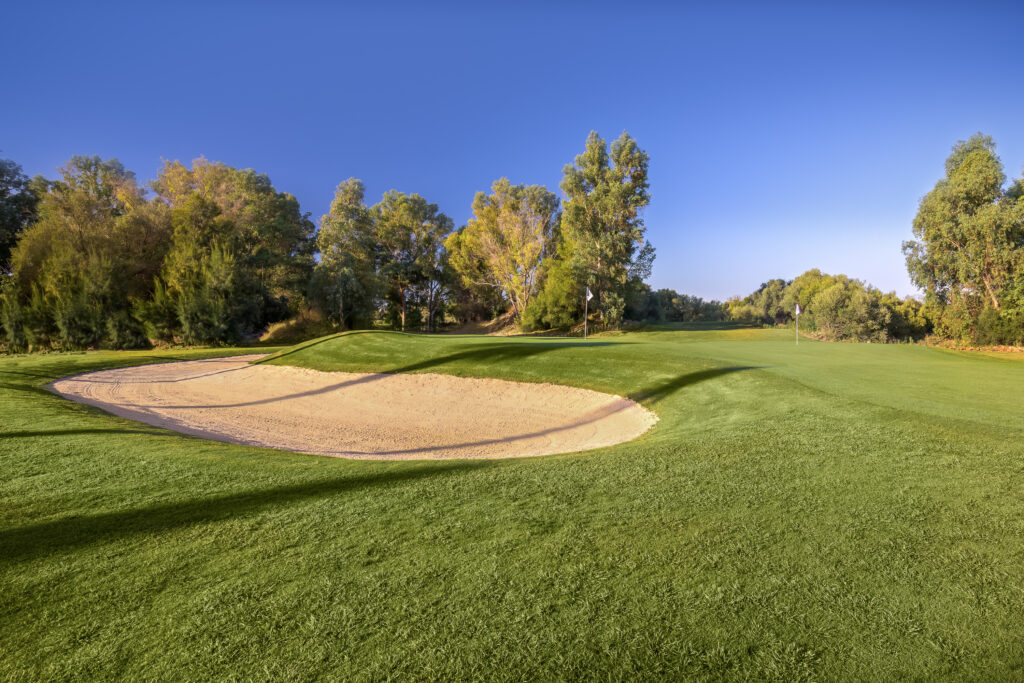 Hole with bunker around with trees around at Montecastillo Golf Course