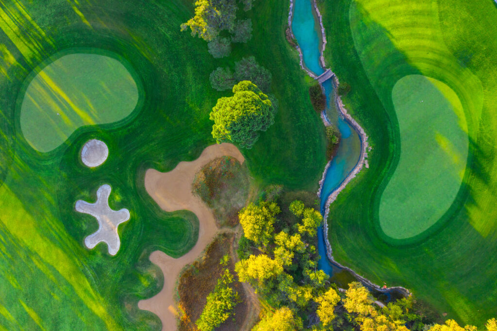 Aerial view of stream running through fairway with bunkers and trees around at Montgomerie Maxx Royal Golf Course