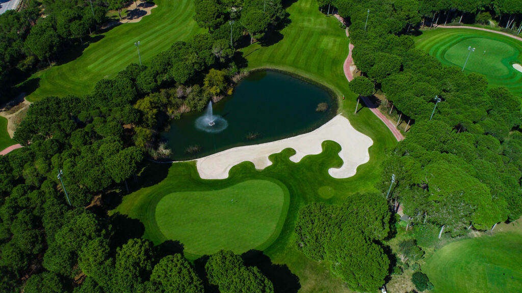 Aerial view of fairway with bunkers and trees at Montgomerie Maxx Royal Golf Course with a lake