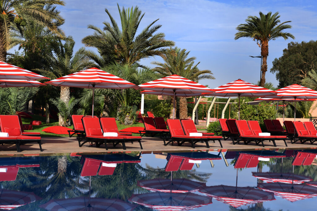 Loungers by outdoor pool at Movenpick Hotel Mansour Eddahbi Marrakech