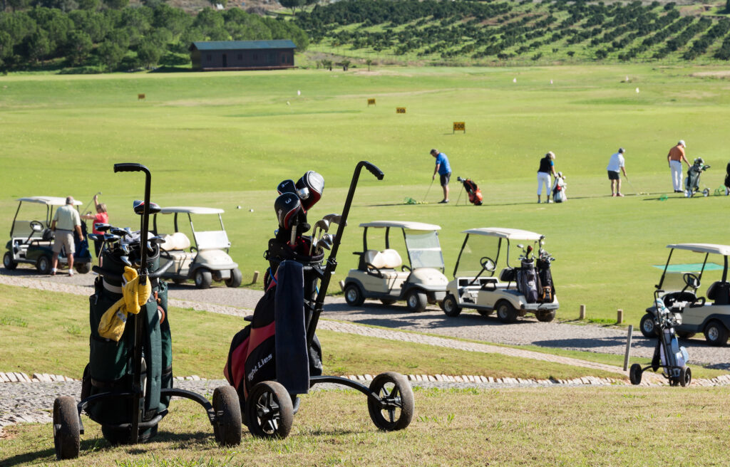 Golf trolleys with buggys in the background at Morgado golf course
