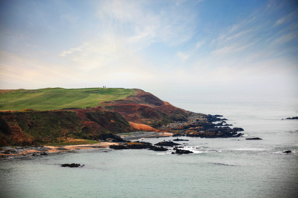 Fairway and cliffside at Nefyn & District Golf Club with ocean