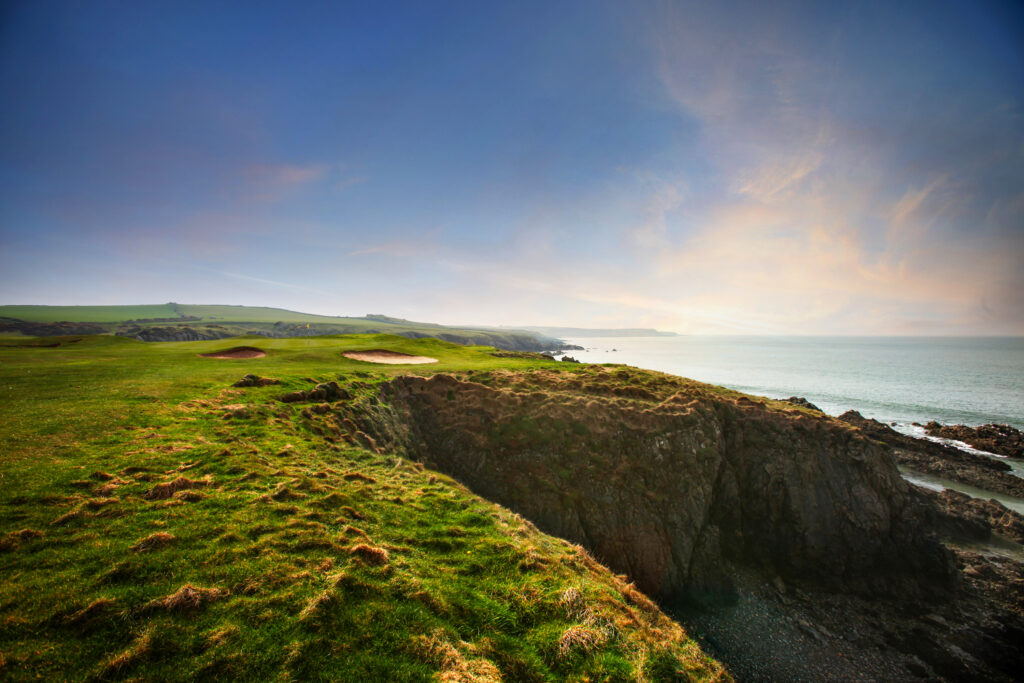 Bunkers on fairway with cliffside and ocean at Nefyn & District Golf Club