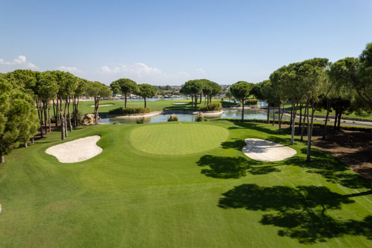 Hole with bunkers at Nobilis Golf Course with trees and lake in background