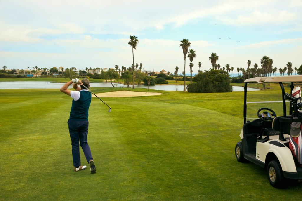 Man playing golf at Real Novo Sancti Petri Golf Club - B Course with buggy