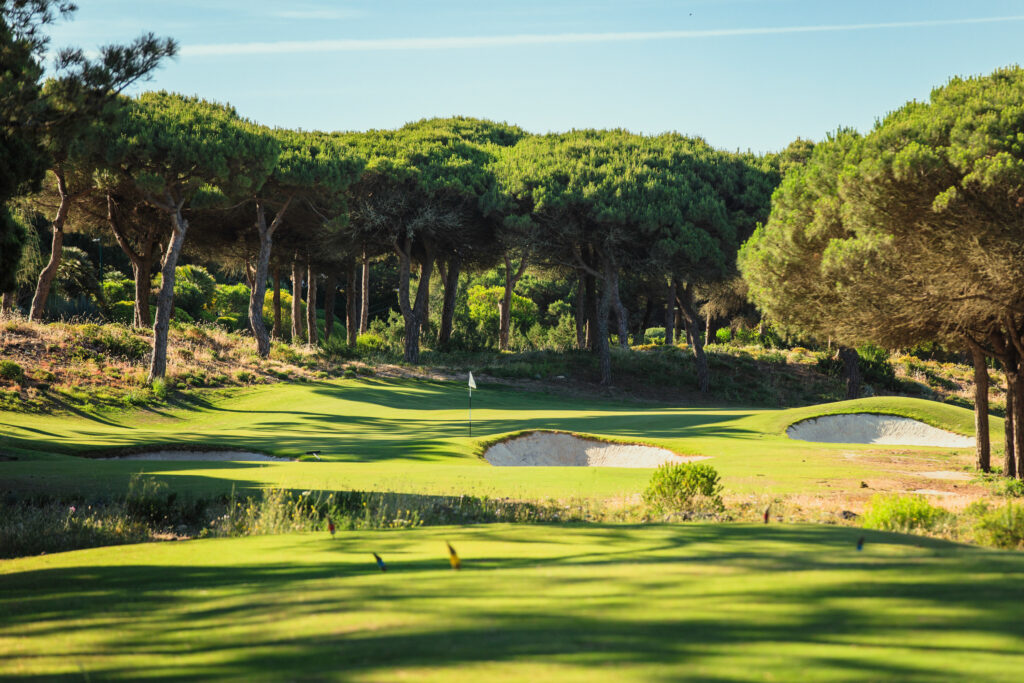 Hole with bunkers surrounded by trees at Oitavos Dunes Golf Course