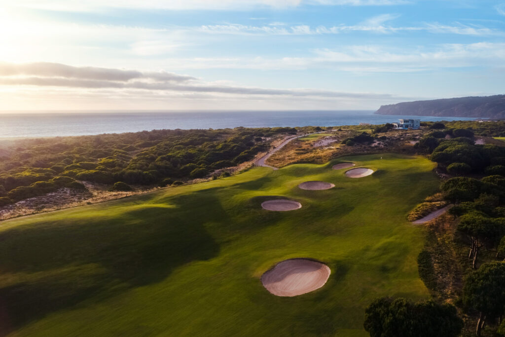 Aerial view of fairway with bunkers and ocean in background at Oitavos Dunes Golf Course