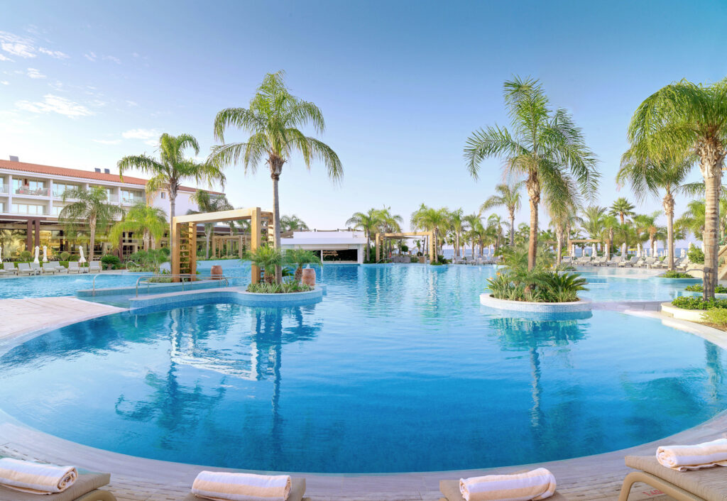 Outdoor pool at Olympic Lagoon Hotel with palm trees around