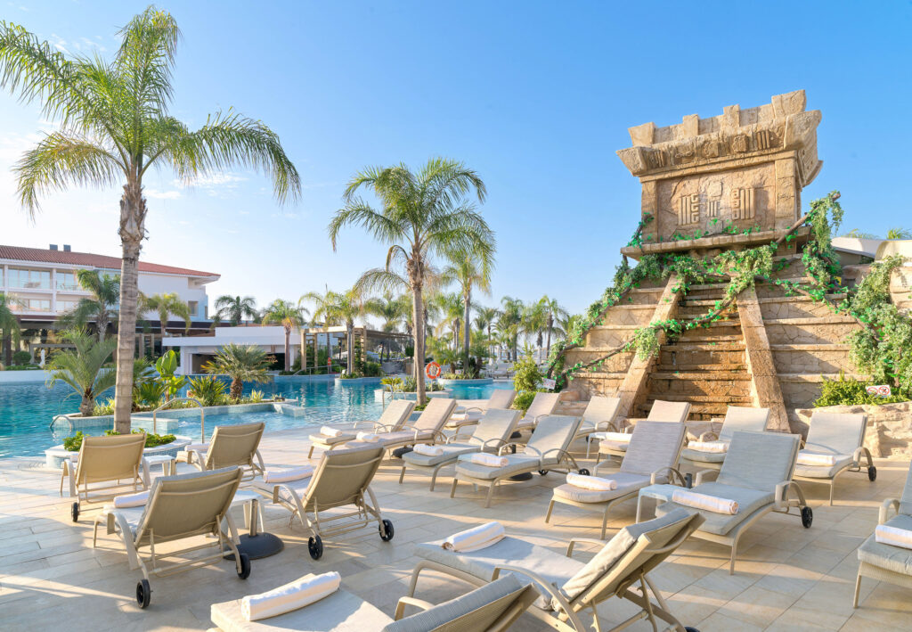 Loungers by outdoor pool at Olympic Lagoon Hotel